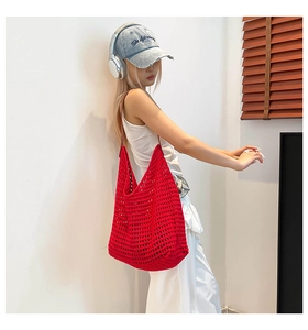 Close-up of red hollow woven cotton shoulder bag with contrast brown leather strap