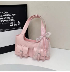 Dettaglio della borsa hobo rosa con doppie tasche a fibbia e un grande fiocco di pizzo