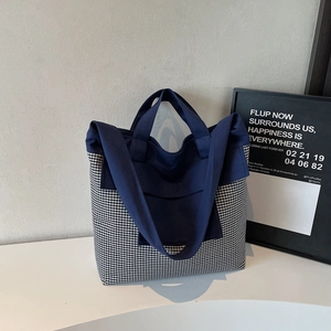 Detail view of large navy blue and gingham checkered canvas tote bag for daily commute