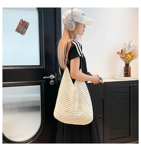 Detailed close-up of a cream woven crochet tote bag with brown leather shoulder straps