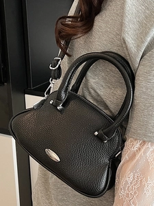 Fashionable black pebbled leather shell handbag with top handles and adjustable strap