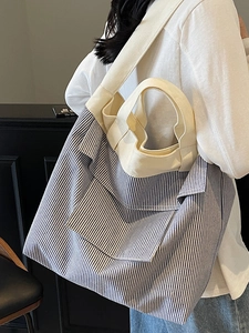 Blue and white striped canvas tote bag with cream straps shown on model for daily commute