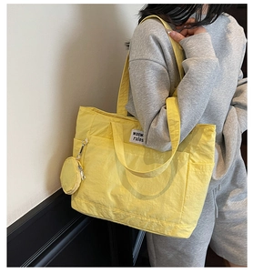 Detail of a bright yellow large capacity canvas tote bag with a matching mini pouch