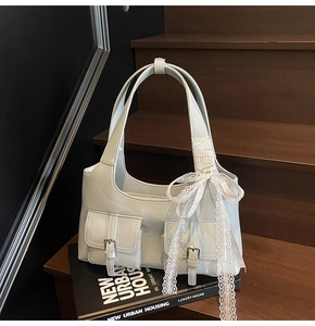 Dettaglio borsa sottobraccio azzurra con fiocco in pizzo e fibbie metalliche