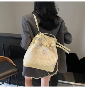 Dettaglio della borsa tote a righe gialle con stampe di cartoni animati e tracolla regolabile