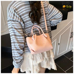 Pink woven texture handbag shown on model for daily commuting style and size reference