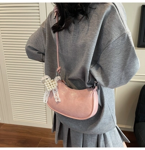 Detailed macro view of pink crescent moon bag featuring a pearl lace bow pendant and zipper