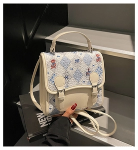 Détail du sac blanc crème avec motif à carreaux bleus et broderie d'ours mignon