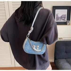 Detail showing blue denim hobo bag with pearl chain and metallic silver knot strap