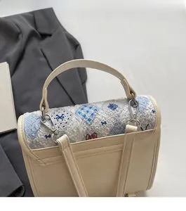 Détails des crochets dorés et de la bandoulière réglable sur sac à dos beige