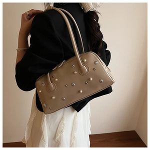 Detailed view of the vintage beige shoulder bag with star and pearl rivet embellishments