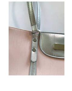 Détail rapproché de l'anneau argenté et des coutures sur un sac cabas rose