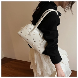 Detail of white leather shoulder bag with silver star studs and pearl embellishments
