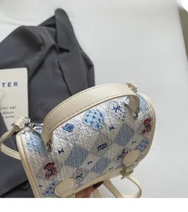 Détail de la poignée crème et de la texture durable du sac à main imprimé ours mignon