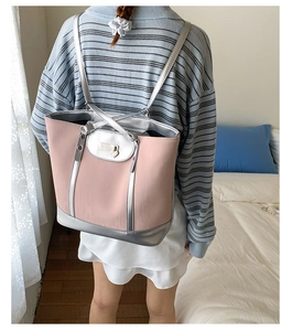 Sac fourre-tout rose et argent porté en sac à dos avec un pendentif cœur en métal