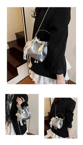 Détail d'un sac seau argenté métallisé avec des breloques en perles et un ornement papillon