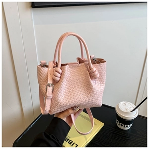 Detailed macro view of the pink bucket bag with woven texture and knotted handles