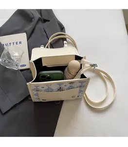 Vue intérieure d'un sac beige montrant un compartiment avec téléphone et parapluie
