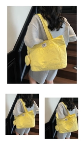 Detail of bright yellow large tote bag with brand label and matching round coin purse pouch