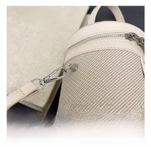 Dettaglio del gancio in metallo argento e della trama intrecciata di questa borsa beige