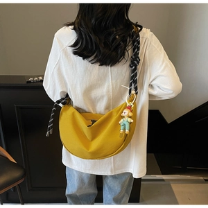 Borsa a mezzaluna giallo zenzero con tracolla a righe e ciondolo a forma di clown