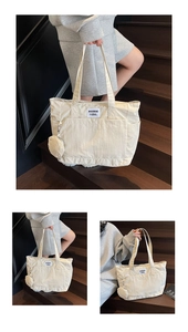 Detail of off-white canvas tote bag featuring small round coin purse and logo patch