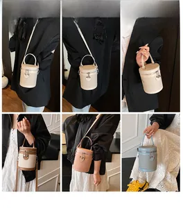 Dettagli di borse a secchiello cilindriche intrecciate in beige, marrone e blu con cuori