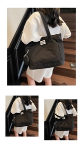 Detail of black nylon tote bag featuring a branded white label and round coin purse attachment