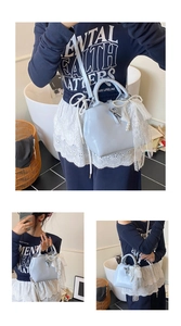 Detail of light blue bucket bag with silver toggle closure and large white lace bow