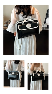 Detail of contrast stitch shoulder bag with top handle and adjustable straps
