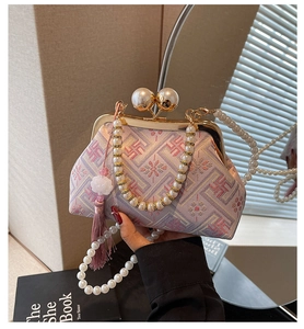 Detailed embroidery on vintage Chinese qipao bag featuring pearl handle and silk tassel