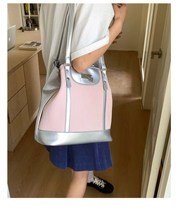 Détail du sac fourre-tout rose avec fermoir en cœur et finitions argentées sur modèle