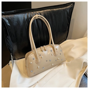 Detail of beige faux leather shoulder bag with faux pearls and star-shaped metal studs