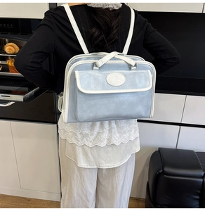 Detail of light blue lychee pattern PU leather tote with white trim and embossed logo
