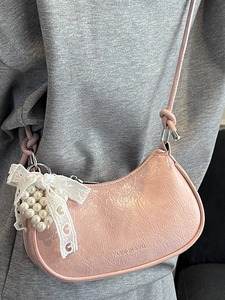 Pink crescent crossbody bag in crinkled patent leather with lace bow pearl charm