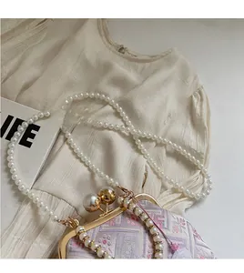 Detailed view of embroidery pattern and pearl shoulder chain on Chinese style handbag