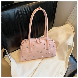 Detail of pink patent leather handbag with silver stars and faux pearl decorations