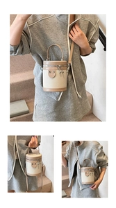 Dettaglio della borsa a secchiello in tela e pelle con patch a cuore e zip in metallo