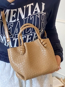 Chic woven bucket bag in khaki brown featuring round handles and adjustable crossbody strap