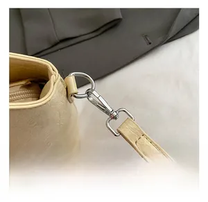 Detailansicht der beigen Eimer-Tasche mit strukturierter Lederoptik und silbernen Haken