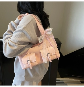 Dettaglio borsa tote rosa con fiocco in pizzo bianco e doppie tasche con fibbie argento