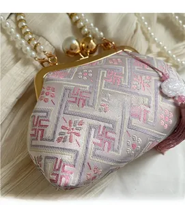 Detail view of vintage embroidery handbag with golden frame and large pearl clasp