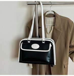 Detail of vintage tote bag with contrast piping and magnetic front pocket on blazer