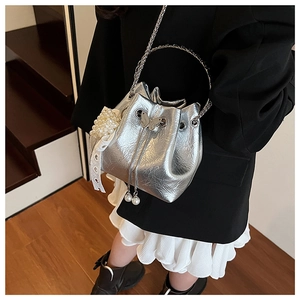 Détails du sac seau argenté avec fermoir papillon, breloques perles et cuir métallisé