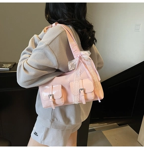 Dettaglio della borsa Y2K rosa con decorazione in pizzo e tasche con fibbia in metallo