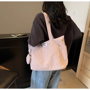 Detail view of pink canvas tote bag with a small matching pouch for student daily use