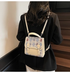 Détail de la broderie d'ours et du motif matelassé sur un sac à dos mode beige et bleu