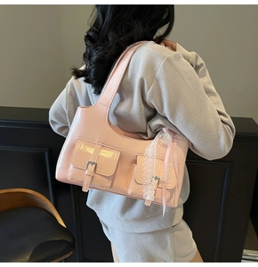 Dettaglio della borsa in pelle verniciata rosa con pizzo e fiocco decorativo