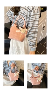 Detail der rosa glänzenden Beuteltasche mit weißer Spitzenschleife und Perlenanhänger