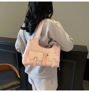 Dettaglio borsa rosa con fiocchi di pizzo e fibbie argentate sulle tasche laterali